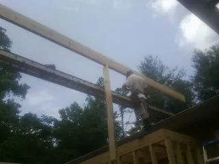 Carpenter setting a ridge beam over a new addition frame — Ice Dam Removal by Roofing Brothers in Chewelah