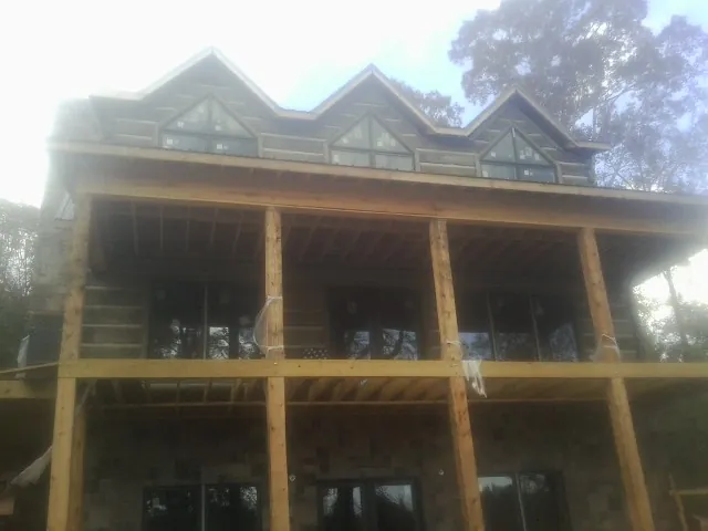 Dormers and porch framing on a large log home under construction — Roof Coating work by our crew in Chewelah