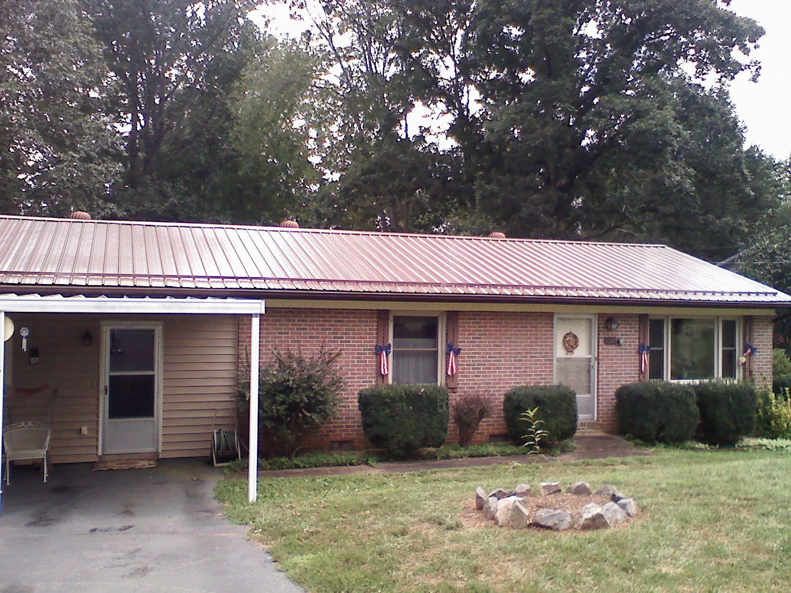 Bronze metal roof and carport on a brick ranch home — Roof Repair work by our crew in Chewelah